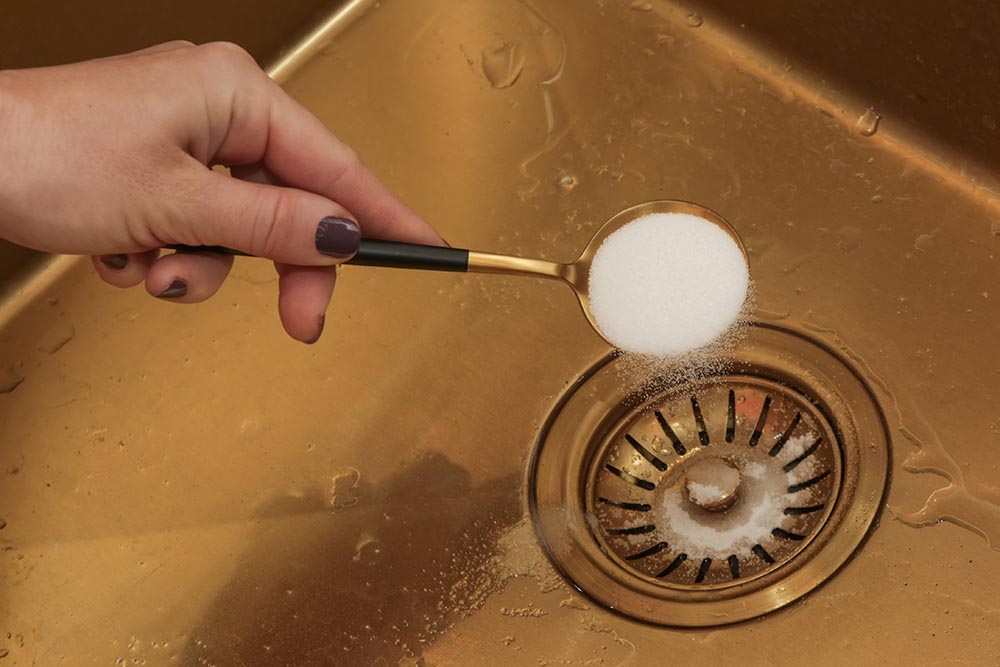 Cleaning kitchen sink with baking soda